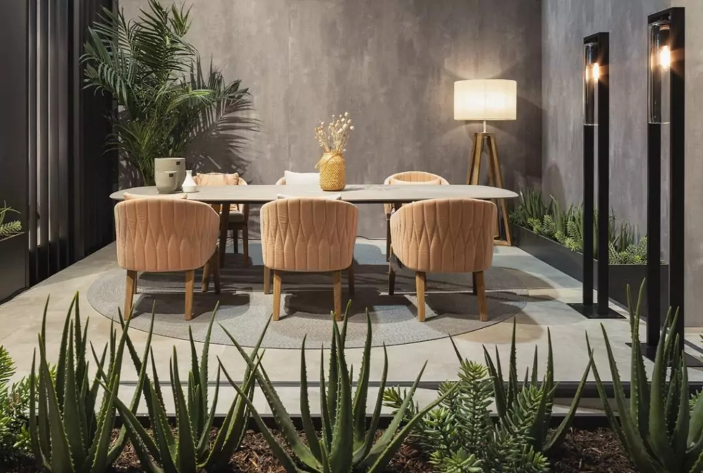 Moderne eettafel met drie zalmkleurige stoelen omgeven door potplanten en slangenplanten als groendecoratie.